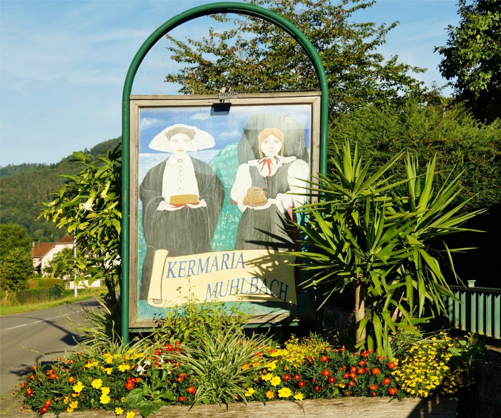 Outdoor sign with painted illustration of two people in period clothing, surrounded by colorful flowers and greenery.
